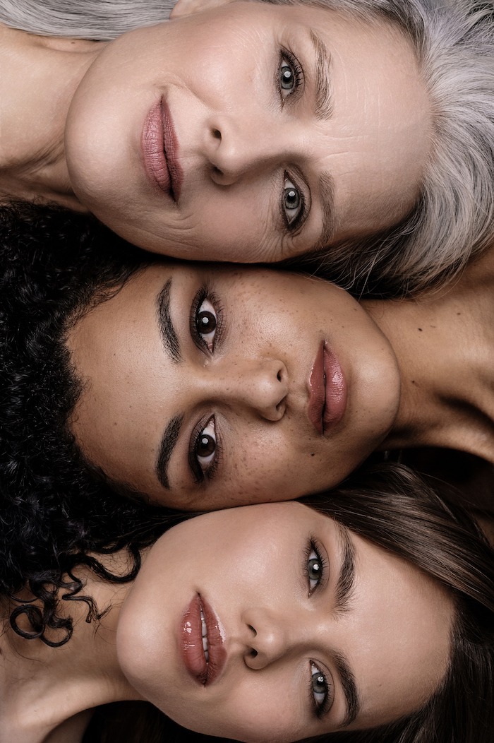 Porträt von drei Frauen unterschiedlicher Ethnien, die gemeinsam in die Kamera blicken, symbolisierend Vielfalt und Schönheit in allen Altersstufen.
